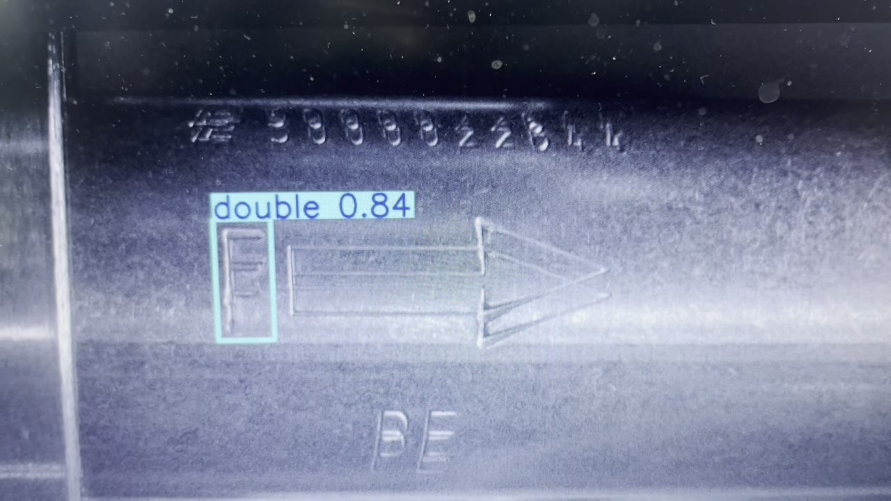 Raw monochrome image of metallic cylinder with AI detection bounding box showing double embossing